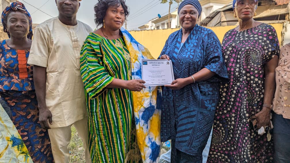 "Participants displaying their Adire creations, and  certificates of participation at the Ajowa Funfair."