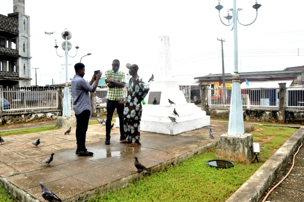 Badagry Tour Guide with tourists at the seat of Agia tree, where christianity was first preached. Tour Africa Magazine. 